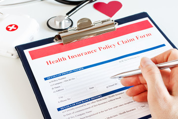 Blank health insurance policy claim form with stethoscope on clipboard.