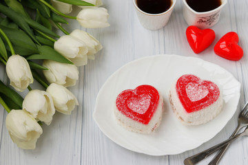 Heart-shaped jelly cakes, coffee and tulips on a white background, Valentine's Day dessert, Closeup