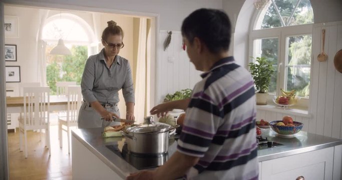WS Senior Couple Cooking Soup in Open Plan Kitchen. Shot in R3D (6K RED RAW)