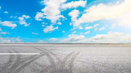 Empty asphalt road and blue sky with white clouds in summer