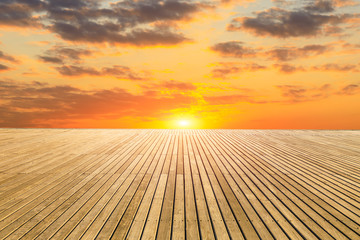 Fototapeta na wymiar Empty wooden board square and sunset yellow sky