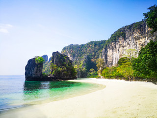 Island beach with limestone rocks and long tail boats