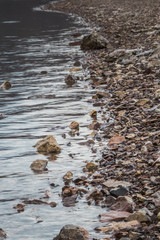 rocky shore of a reservoir with clear blue water high in the mountains