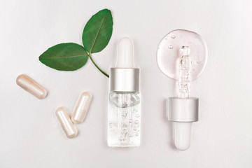 Bottle with hyaluronic acid on silver background. Concept of modern beauty. Flat lay style.