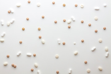 Scattered pills on a white background. Bright monochrome composition. Pharmacology