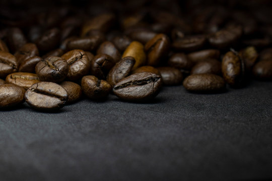 Coffee in beans on dark background. Abstract background texture.Coffee beans texture. Food background of coffee beans © Александр Клюйко