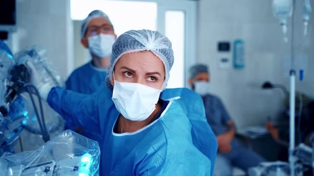 Robot assisted surgical system. Modern equipment in operating room. Team surgeon at work in operating room.