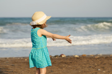 niña con sombrero descubriendo la playa