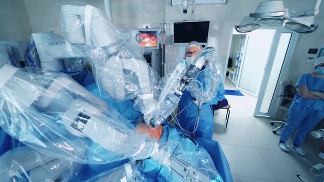 Robotic Surgery. Group of surgeons in operating room with surgery equipment. Future of Medicine