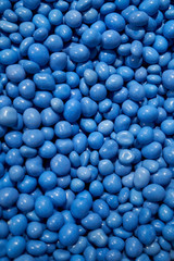 Chocolate candies in blue glaze. Colorful dragees. Blue jelly beans dragee background. Candy shop. Vertical image.