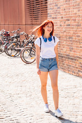 Fototapeta na wymiar Girl walks along bicycle parking lot in sunny day