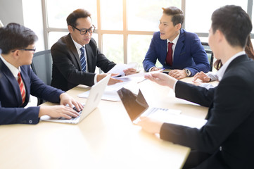 Asian businessmen talk in a meeting room during an office meeting.