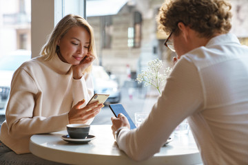 Couple sit in cafe indoors drinking coffee