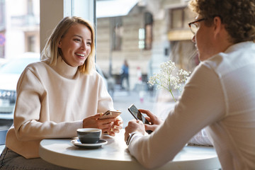 Couple sit in cafe indoors drinking coffee