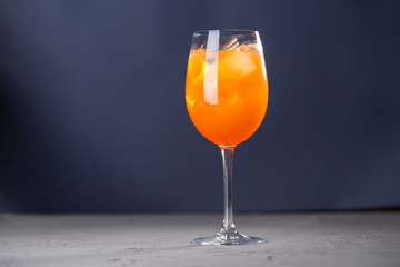 Cocktail with Orange juice, cinnamon, mint and ice on blue background
