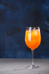 Cocktail with Orange juice, cinnamon, mint and ice on blue background