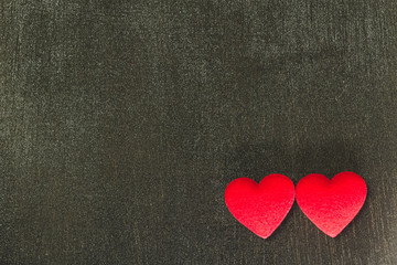 Obraz premium Two red hearts on black wooden background darktone, copy space, Valentine's Day concept.