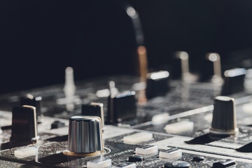 music, technology, people and equipment concept - man using mixing console in sound recording...