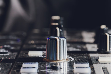 music, technology, people and equipment concept - man using mixing console in sound recording...
