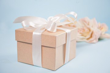Gift box with flowers beige roses on the background.