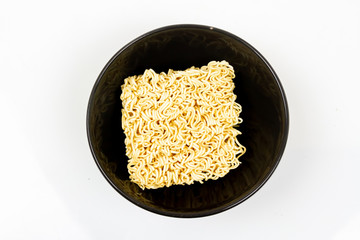 Top view of Instant noodles in black bowl isolated on white background.