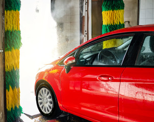 Red car at an automatic car wash.