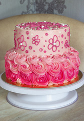 Festive, pink cake for a girl with cream roses on a light background