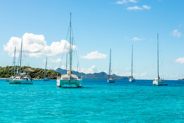 Turquoise colored sea with ancored yachts and catamarans, Tobago Cays tropical islands, Saint Vincent and the Grenadines, Caribbean sea