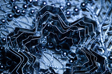 Metal molds for biscuits of various shapes on a gray background with New Year's garland