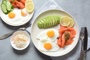 Healthy breakfast concept, fried eggs, avocado and smoked salmon, top view