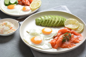 Healthy breakfast concept, fried eggs, avocado and smoked salmon, top view