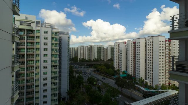 Ultra high definition 4k time lapse movie of moving clouds and blue sky over apartment buildings or flats in Punggol estate with neighborhood traffic and covered walkway in Singapore 3840x2160