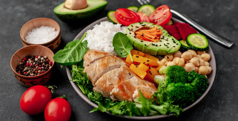Bowl Buddha. rice, chicken breast, broccoli, pumpkin, avocado, chickpeas, carrots, cucumber, beets, a stone background