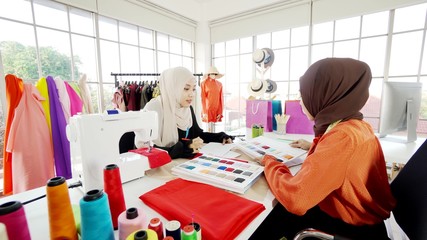 2 Asian Muslim female designers designing clothes Is in the office very often