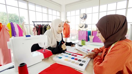 2 Asian Muslim female designers designing clothes Is in the office very often