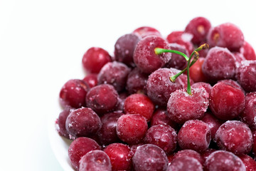 frozen fresh cherry with sprigs on a white background. an ingredient for smoothies and smoothies. ice crystals on the berry. close up.