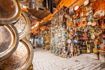 Narrow street in medina of Marrakech full of shops with souvenirs