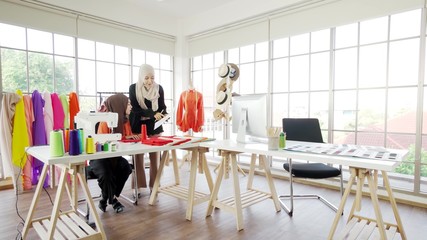 Two Asian Muslim girls Currently working on designing a design within the office.