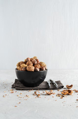 Peanuts and nuts in a bowl on a delicate grey background