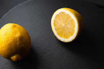 Fresh lemon cut in half on a black background
