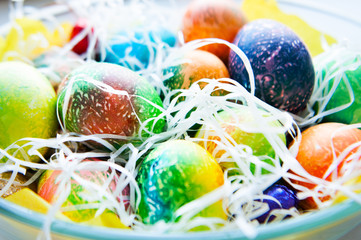 Many colorful easter eggs in the plate. 