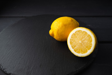 Fresh lemon cut in half on a black background