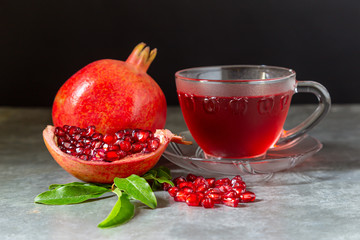 Pomegranate juice in clear glass and pomegranate on a wooden table
