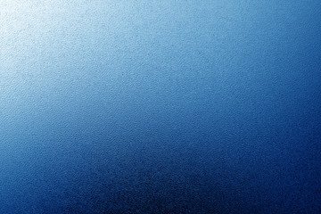Fototapeta na wymiar Ground glass texture with light with blur effect in navy blue tone.