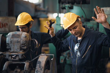 Shot of two industrial workers feeling bad with old system in the factory, the worker feels upset...
