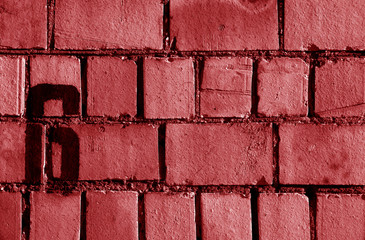 Number 6 in stencil on rusty brick wall in red tone.