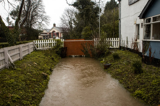 Image of Storm Ciara in england filling up the local river with water and flooding it so there is no room under the bridge for a drop more water causing issues for local houses and business'