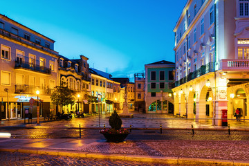 Fototapeta premium View of city center at night with illuminated buildings and dark blue sky in Aveiro, Portugal