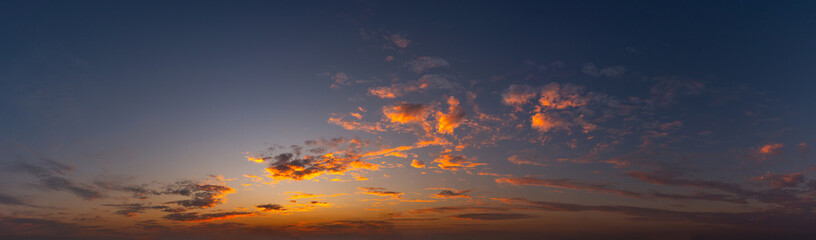 Panorama Sunset with clouds, in orange and colorful shades,World Environment Day concept: Fiery orange sunset sky with dark clouds.