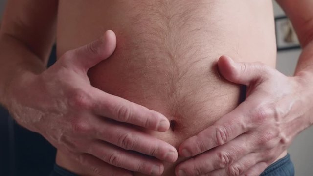 Mature white man inflates his hairy belly, slaps himself with hands, strains it
